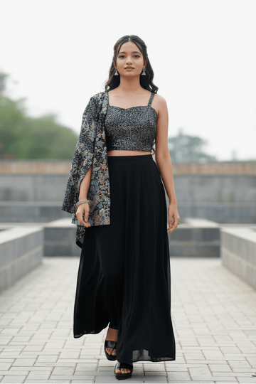 Black Draped Skirt Paired With A Sequined, Dark-Colored Crop Top And A Patterned Shrug For Women & Girls - Aira Fabrics Designer Studio