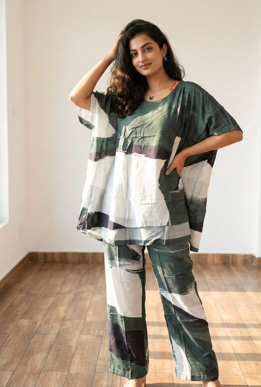 Woman wearing a green and white patterned outfit in a room with wooden flooring.